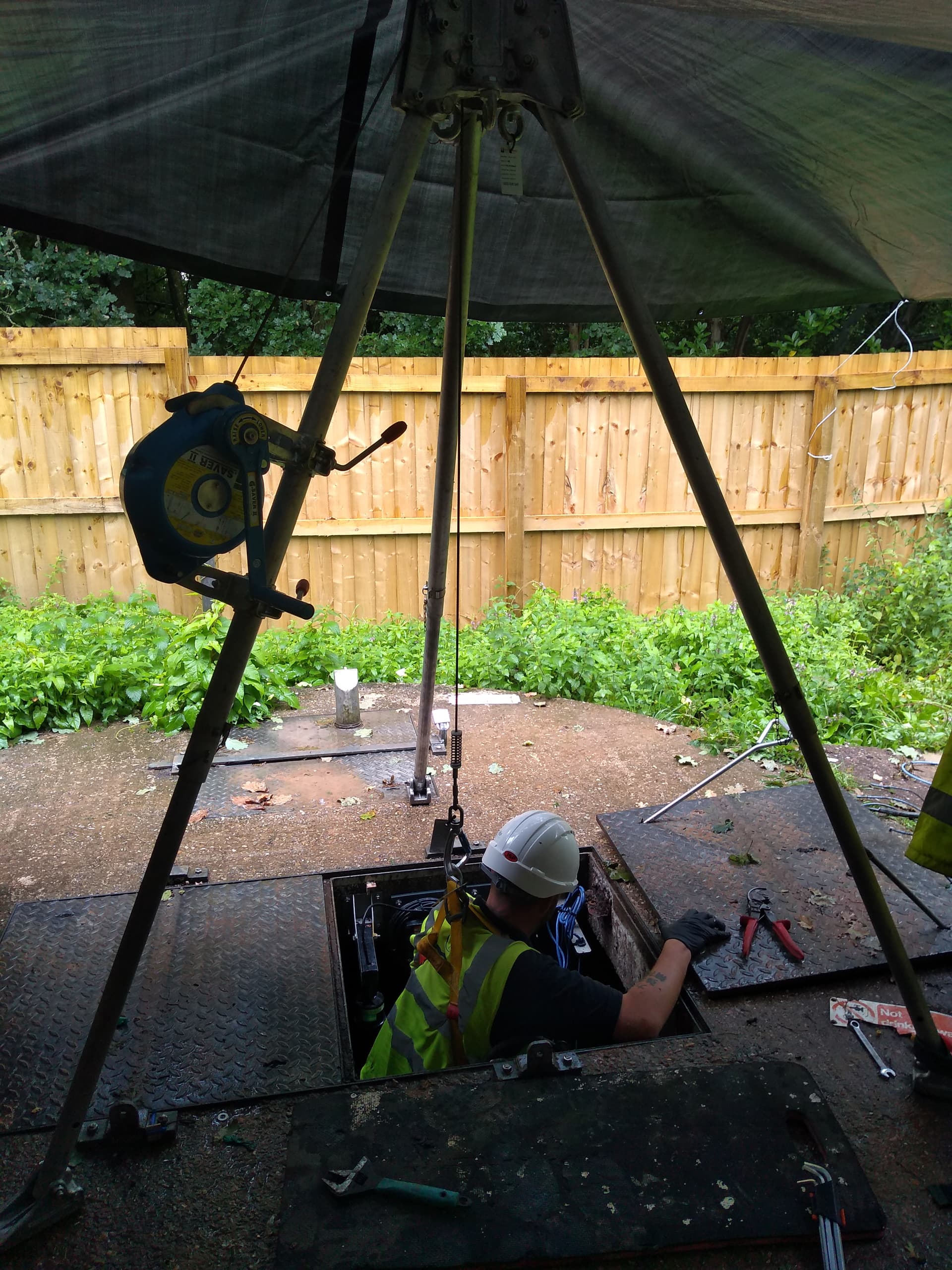 Elite Southwest engineer entering a confined space chamber under tripod and winch rescue cover